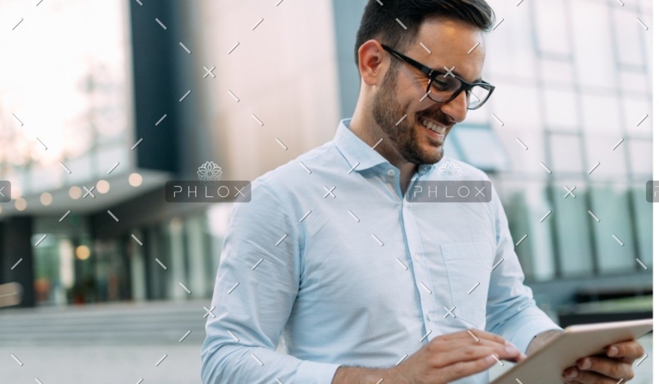demo-attachment-609-portrait-of-businessman-in-glasses-holding-tablet-AWVHCJU
